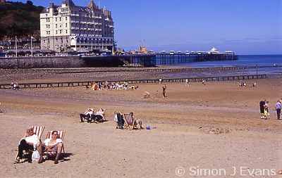 Sunbathers on the beach and the pier at Llandudno